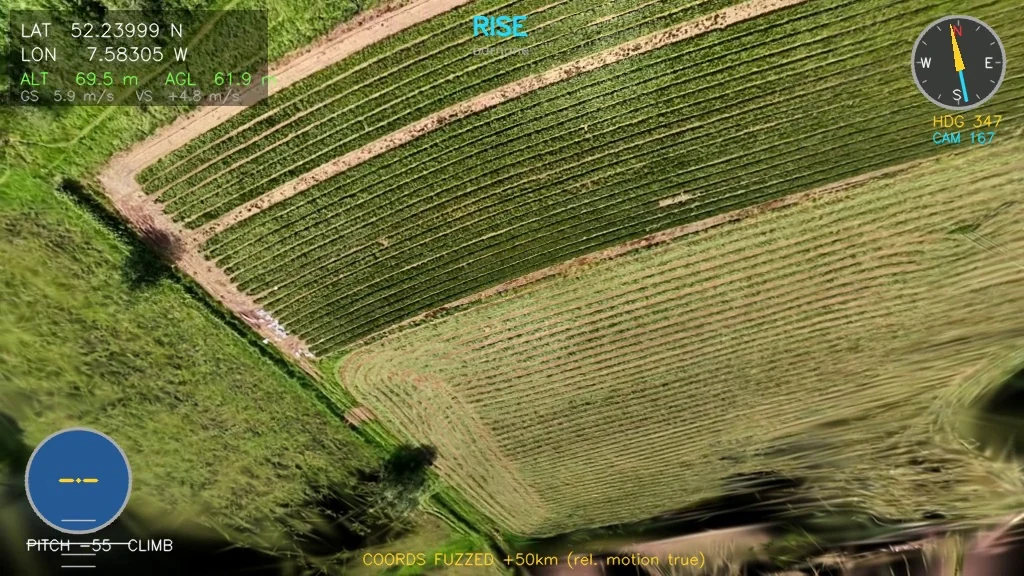 Rendered aerial frame over cut farmland showing crop lines, with a flight HUD.